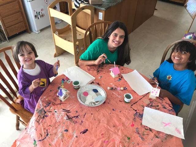 Three young children working on craft projects together