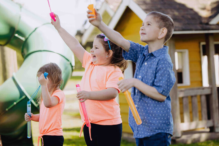 Three children blowing bubbles