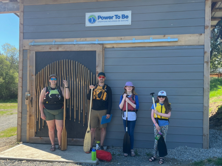 Family standing with paddles at Power to Be.